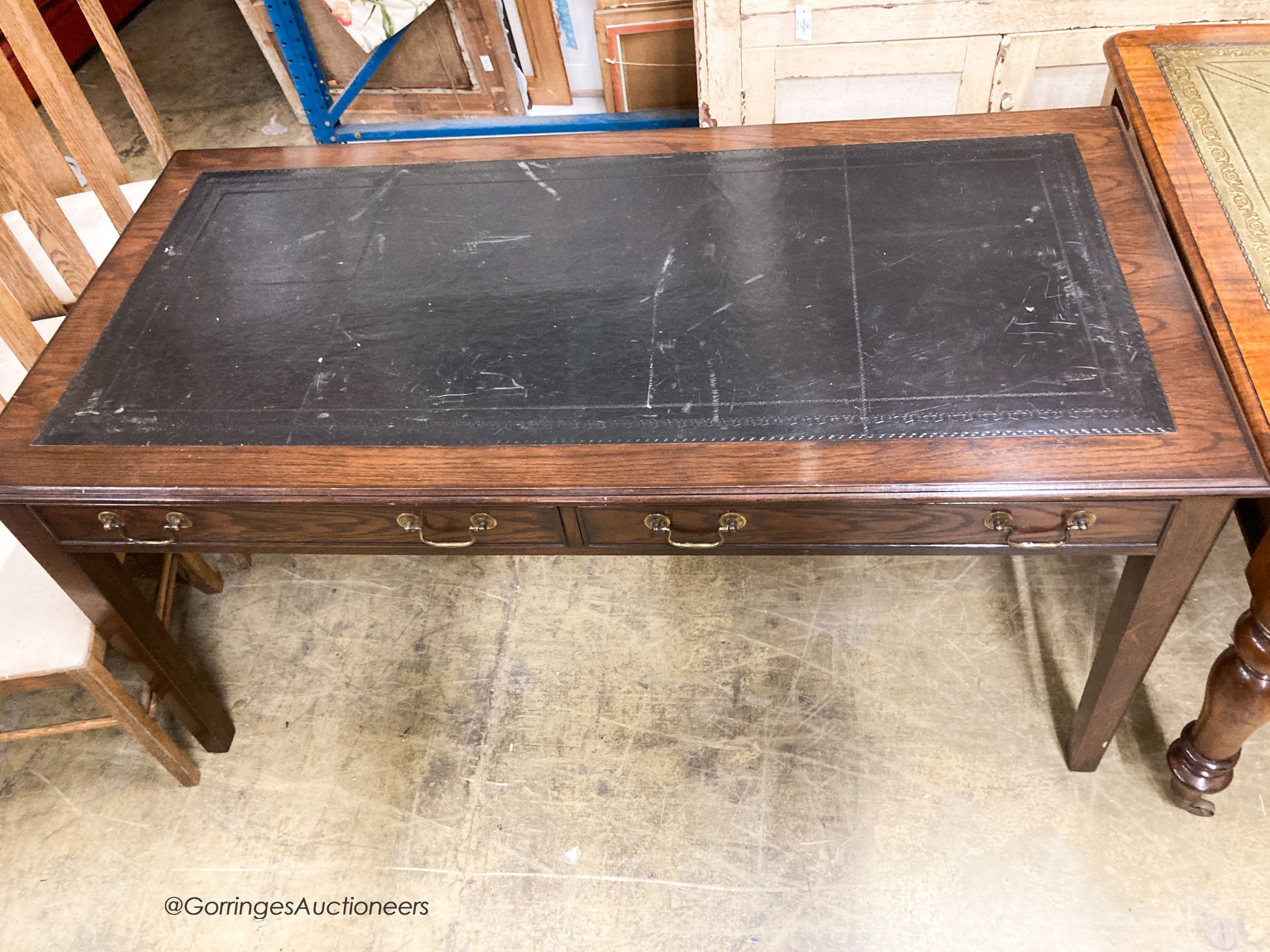 A reproduction oak two drawer writing table, W.160cm D.80cm H.78cm